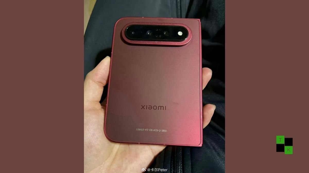 A modern book-style foldable smartphone in a deep dark cherry finish partially open on a minimalist dark studio surface.