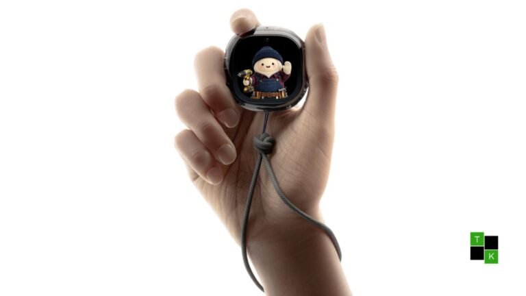 The Meta Muse Charm handheld device resting on a table beside keychains, displaying an illuminated avatar screen.