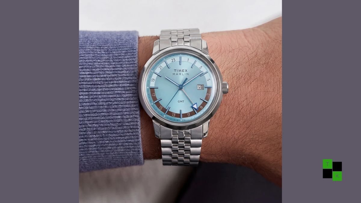 Two Timex Marlin Quartz GMT watches displaying the ice blue sunray dial on steel and chocolate brown dial on leather.