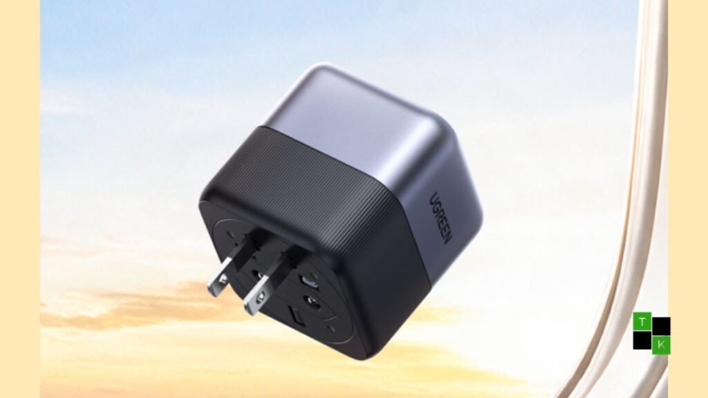 The Ugreen 65W GaN travel adapter showing its compact cubic metallic gray body and 360-degree rotating plug mechanism.
