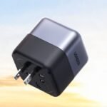 The Ugreen 65W GaN travel adapter showing its compact cubic metallic gray body and 360-degree rotating plug mechanism.