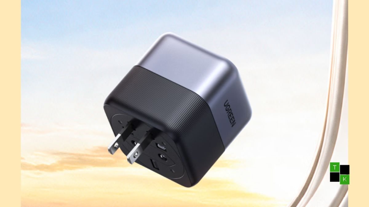 The Ugreen 65W GaN travel adapter showing its compact cubic metallic gray body and 360-degree rotating plug mechanism.