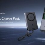 The UGREEN MagFlow Pro power bank magnetically attached to an iPhone showing its transparent liquid-cooling chamber and digital screen.