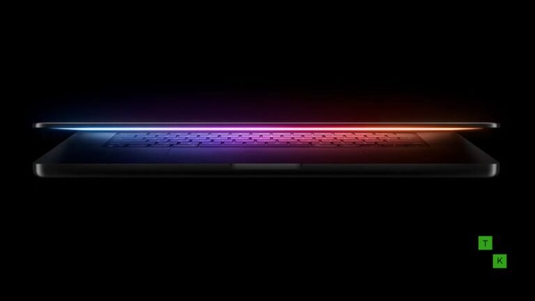 An Apple OLED MacBook Pro resting open on a dark granite workstation, showcasing deep blacks, razor-thin bezels, and a subtle punch-hole camera.