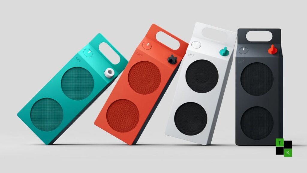 The CMF Speaker S portable Bluetooth speaker in bold Orange and Turquoise resting on a wooden picnic table showing its milk-carton profile, tactile knob, and carabiner hook.