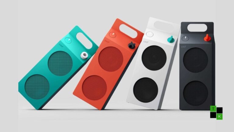The CMF Speaker S and CMF Speaker M by Nothing displayed on a studio table showing their milk-carton shape, top carry handle, and orange volume dial.