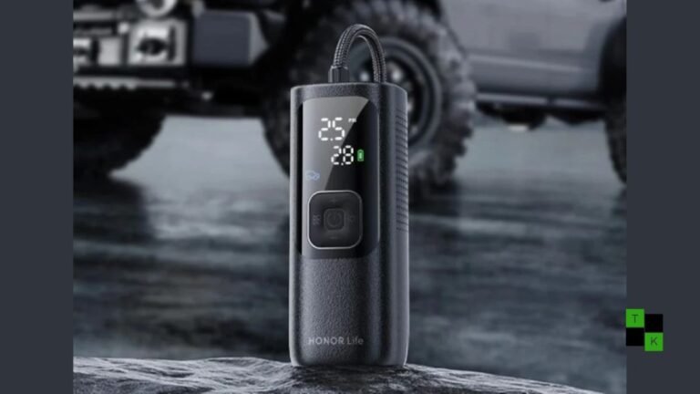 The Honor Life Air Pump Lite portable air compressor resting on clean tarmac next to a car wheel showing its digital pressure screen.