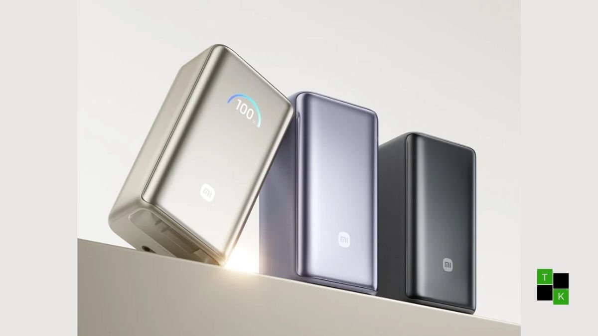 Xiaomi 10,000mAh 55W power bank in Deep Titanium and Iris Purple resting on an executive desk showing its 70cm retractable USB-C cable and illuminated smart display.